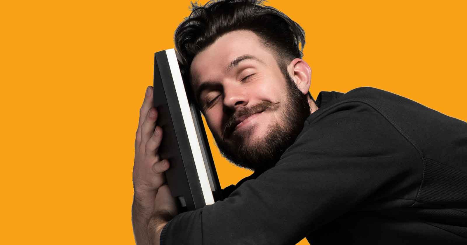 Man smiling and holding a device next to his face