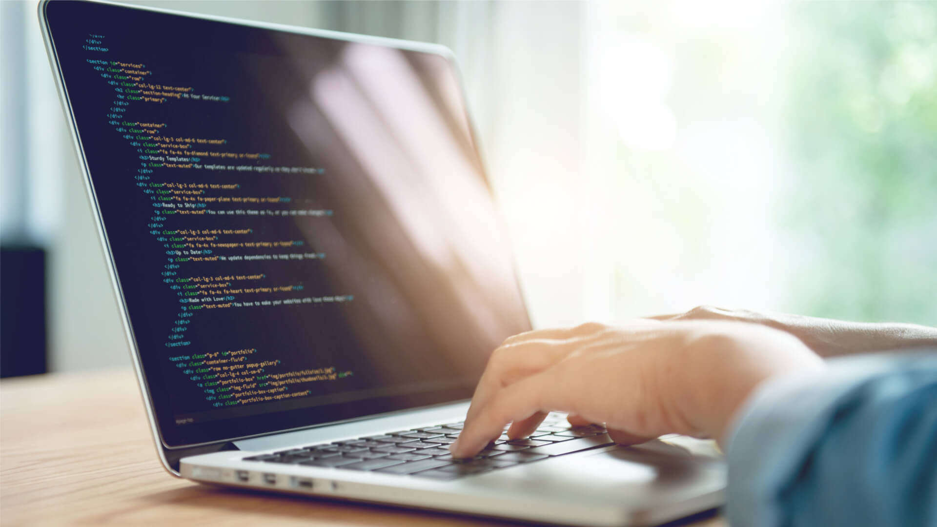 man typing code on laptop